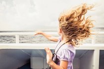 Jeune fille debout sur le bateau — Photo de stock