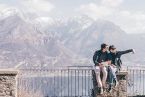 Casal sentado na parede terraço sobre a montanha — Fotografia de Stock
