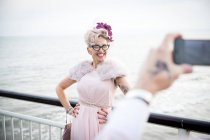 Man taking photograph of woman on pier — Stock Photo