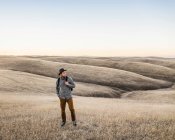 Hombre mirando colinas de pradera onduladas - foto de stock