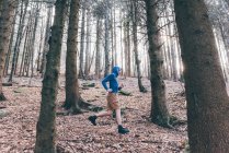 Corredor masculino corriendo en bosque escarpado - foto de stock