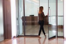 Businesswoman going through office door — Stock Photo