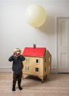 Хлопчик стоїть біля лялькового будинку — стокове фото