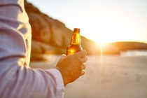 Homme tenant une bouteille de bière — Photo de stock
