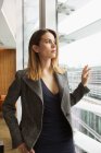 Businesswoman looking out of office window — Stock Photo