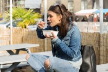 Jovem mulher comer comida takeaway — Fotografia de Stock