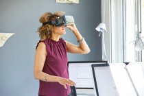 Жінка дивиться через гарнітуру віртуальної реальності — стокове фото