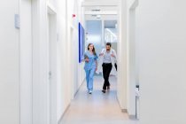Médicos caminando por el pasillo del hospital - foto de stock