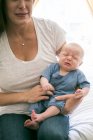 Mother sitting with crying baby boy — Stock Photo