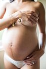 Femme enceinte partiellement vêtue , — Photo de stock