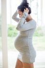 Mujer embarazada usando vestido apretado - foto de stock