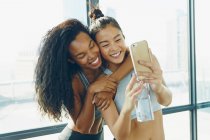 Две молодые женщины в спортзале, делают селфи — стоковое фото