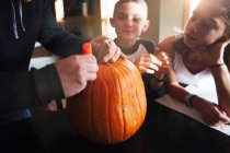 Father and children pumpkin carving — Stock Photo