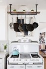 Pans hanging above stove in kitchen — Stock Photo