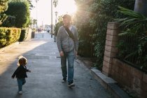 Father and baby boy walking in street — Stock Photo