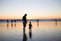 Матір та дитинча хлопчика на пляжі — стокове фото