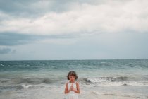 Menina orando na praia — Fotografia de Stock