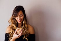 Young woman holding doughnut hole — Stock Photo