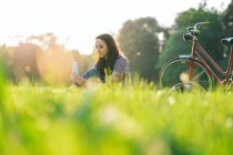 Жінка використовує мобільний телефон на траві — стокове фото