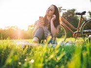 Женщина с телефоном на траве — стоковое фото