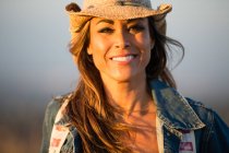 Retrato de mujer madura, al aire libre, con sombrero de vaquero, sonriendo - foto de stock