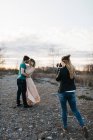 Photographer photographing couple, couple kissing in rural setting — Stock Photo