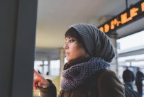 Femme en bonnet tricoté à l'aide d'un écran tactile — Photo de stock