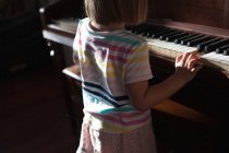 Дівчина стоїть і грає на піаніно — стокове фото