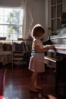 Девушка стоит и играет на пианино — стоковое фото
