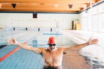 Uomo a braccia aperte in piscina — Foto stock
