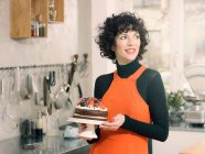 Donna in possesso di torta al cioccolato — Foto stock