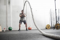 Человек тренируется с боевой веревкой — стоковое фото