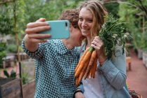 Casal no jardim com cenouras — Fotografia de Stock