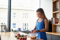 Young woman at kitchen table — Stock Photo