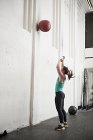 Woman throwing fitness ball — Stock Photo