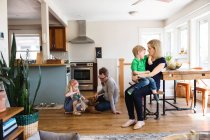 Parents in kitchen together with kids — Stock Photo