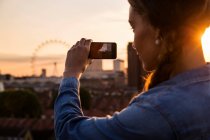 Jovem mulher fotografando skyline — Fotografia de Stock