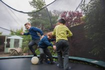 Jungen auf Trampolin spielen Fußball — Stockfoto