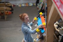 Frau arbeitet im Skateboard-Shop — Stockfoto