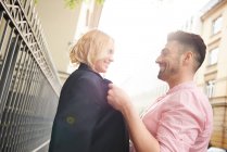 Man sharing suit jacket with woman — Stock Photo