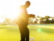 Jogador de futebol com bola em campo — Fotografia de Stock