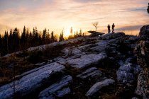 Silhouette von Freunden auf Felsen bei Sonnenuntergang, Bolschoi ural, swerdlowsk, russland, europa — Stockfoto