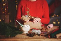 Жінка обгортає різдвяні подарунки — стокове фото