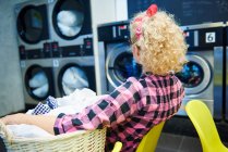 Frau schaut Waschmaschinen zu — Stockfoto