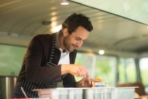 Business owner serving food from van — Stock Photo