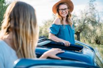 Freunde steigen lächelnd ins Auto — Stockfoto