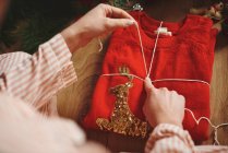 Frau wickelt Weihnachtsgeschenk mit Bindfaden ein — Stockfoto
