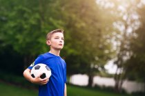 Niño sosteniendo pelota de fútbol - foto de stock