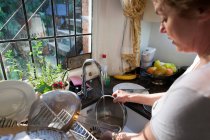 Жінка пральна брудний посуд — стокове фото
