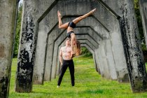 Practicing yoga below concrete bridge — Stock Photo